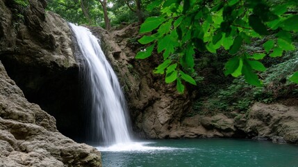 Fototapeta premium Lush waterfall cascading into a tranquil pool, surrounded by dense forest