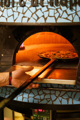 Placing pizza into an oven