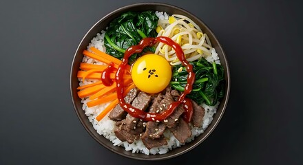Korean bibimbap bowl with beef, egg yolk, vegetables and gochujang sauce, viewed from above