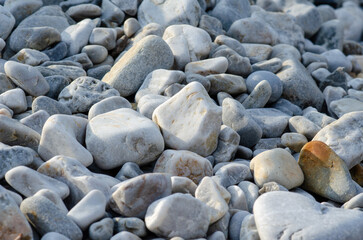 Textured surface of smooth pebbles in white and gray shades, perfect for illustrating nature, tranquility, or beach concepts in creative projects.
