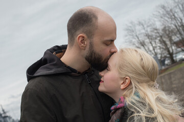 Fototapeta premium Cute woman with long blonde hair and man couple hugging each other kissing at seaside