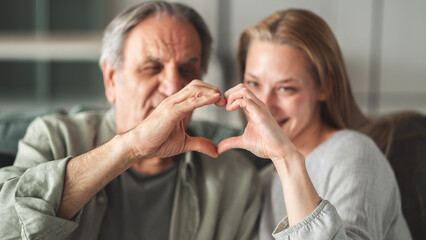 Father and daughter making a heart shape with their hands