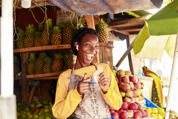happy african fruit vendor smiling while isolated over fruit market
