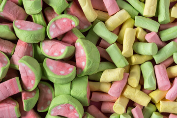 Colored marshmallow background flat lay . Colored marshmallows with watermelon flavor top view .