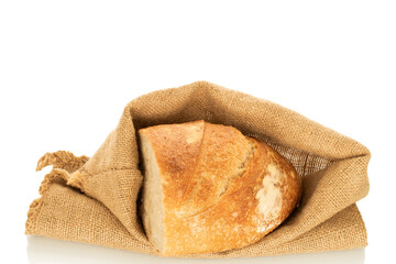One half of a loaf of bread with a jute bag isolated on a white background, close-up.