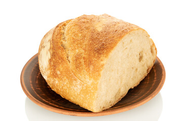 One half of hearth bread on a clay plate isolated on a white background, close-up.