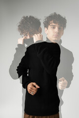 Stylish young man showcasing modern fashion in a creative artistic pose