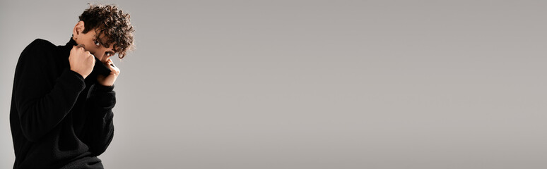 Handsome young man showcasing stylish fashion pose in modern studio setting