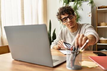 Stylish young man organizing desk tools while working in a cozy home office during the day