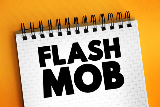 Flash Mob is a group of people who assemble suddenly in a public place, perform for a brief time, then quickly disperse, text concept on notepad