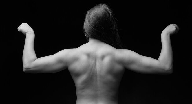 back of a muscular brunette woman with open arms