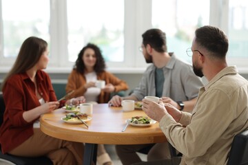Colleagues chatting during lunch break in office