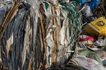 Piles of compressed waste materials are seen at a recycling center, showcasing the critical issue...