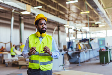 Confident Engineer in Safety Gear Inspecting Manufacturing Facility