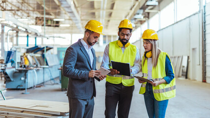 Team of Engineers and Manager Reviewing Plans in Industrial Facility