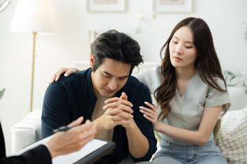 Therapist providing emotional support to worried man during couple therapy session, discussing...