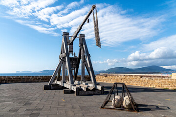 Historic Wooden Catapult with Stone Balls and Scenic Background