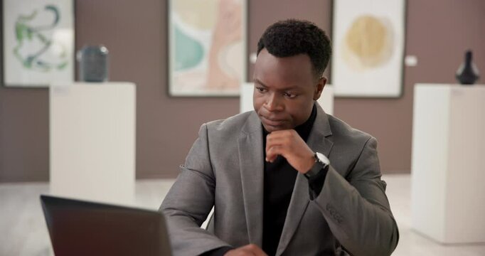 Art, frustrated and black man at exhibition with laptop, culture and online review of creative business. Gallery, sales agent and curator on website for presentation, auction or showroom with doubt