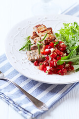 Fried pork tenderloin with tomato salsa. Bright background. Close up.	