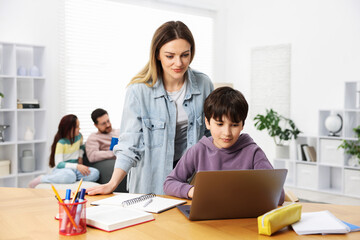 Parents helping their kids with homework at home, selective focus