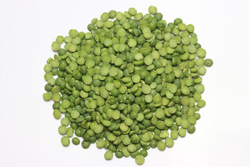 Dried split green peas in a pile on white background
