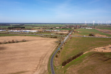 Autobahn zwischen den Feldern und Windpark am Horizont, Drohnenaufnahme, Brandenburg, Deutschland