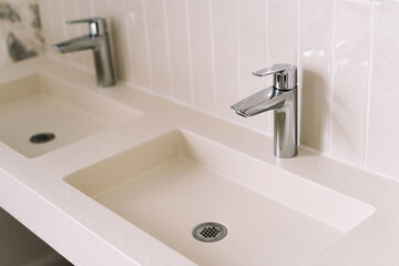 Bright and airy bathroom showcases two modern sinks with polished chrome faucets