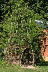  A tall wicker tent made of wood, green foliage. Like an Indian tepee. © Евгений Идт