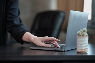 Close-up of a woman typing on a laptop computer keyboard, surfing the internet on an office table, online, working, business and technology, internet network communication concept.