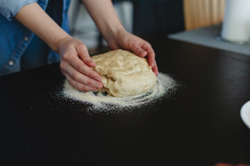 Cooking homemade pizza. Female hands making dough, adding sauce and ingredients.