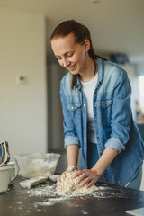 Cooking homemade pizza. Female hands making dough, adding sauce and ingredients.