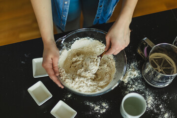 Cooking homemade pizza. Female hands making dough, adding sauce and ingredients.