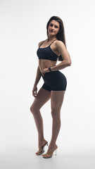 Young beautiful woman with athletic body on white background. Fitness girl