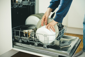 Built-in dishwasher in the kitchen, washing dishes. Plates, cups, glasses are worth washing. 
