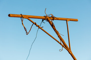 A rusted metal pole with a rope hanging from it