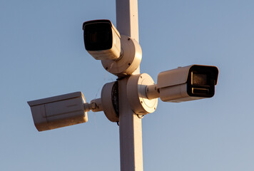 Three security cameras are mounted on a pole
