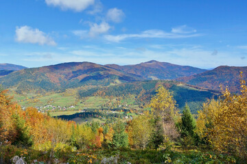 Picturesque beech, birch and pine forests and  houses in Lubomierz village, against the backdrop of the Beskids are very beautiful with bright colors after a fine day.