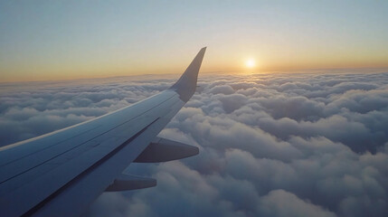 Obraz premium The wing of an airplane against the backdrop of a vibrant, golden sunrise over fluffy clouds.