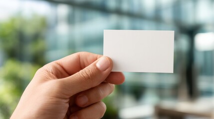 Holding a Blank Business Card in a Bright Office Setting With Blurred Greenery in the Background Generative AI