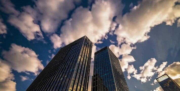 Time-lapse video of modern skyscrapers with moving clouds in the sky