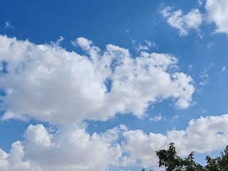Obraz premium Cloudy SKY, Ornamental clouds, Blue SKY with light of sunshine having small and large clouds, Blue SKY with deep dark clouds, Dense Cloudy weather. Timelapse White clouds Panaromic view background 