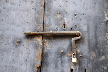 Rusty iron door with padlock in Ragusa