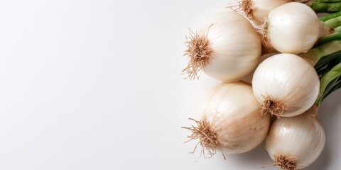  Cluster of fresh white onions with roots and stalks on a white background, with ample copy space for culinary or agricultural themes