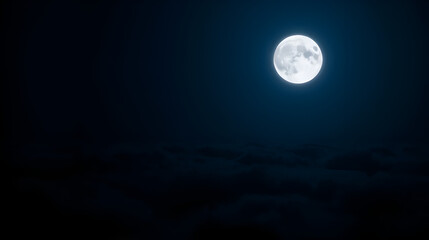Fototapeta premium Full moon shining bright above dark clouds in the night sky with a deep blue color cast