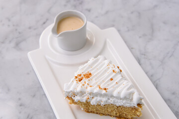 Creamy Tres Leches Cake Slice with Milk Sauce topped with fluffy whipped cream served in tray...