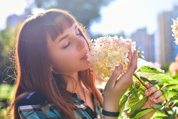 Close-up Focus on Pink Flowers with Woman Smelling in Background