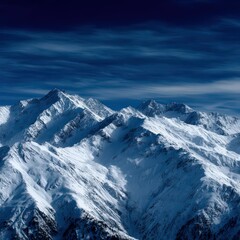 Naklejka premium Snow-covered mountain peaks under a dark blue sky at twilight