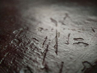 Close-up of a dark, textured surface with scratches and subtle highlights, slightly out of focus