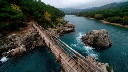 Wooden bridge over river surrounded by lush green forests and mountains on cloudy day