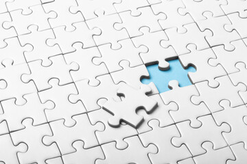 White Puzzle With Missing Piece Revealing a Blue Highlight Beneath